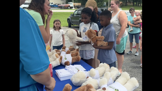 Logan and Isrlia Dunn of Willow Springs rub hearts on their bears to bring them to life, according to Build-a-Bear tradition. Howell County News/Grace Long