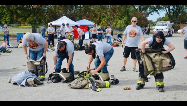 Pomona firefighters race to to suit up and load into the fire truck in the Four Man Scramble. Howell County News/Addison Smith