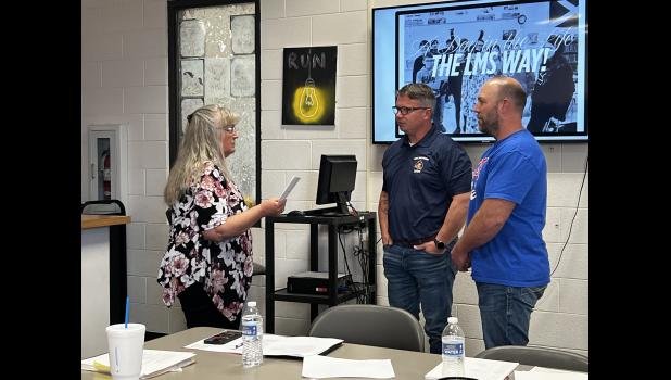 MV-BT School Board Secretary Rhonda Henry swears in board members Dr. Mikael Orchard and Josh Roberts. Howell County News/Laura Wagner