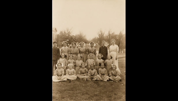 A postcard postmarked September 12, 1911, from Fern and Beulah McKellip, sent to their mother Drusilla McKellip. The photo shows residents of the Soldiers and Sailors Orphans Home located in Normal, Illinois. Fern, age 15, is in the back row, 4th from the left, and Beulah, age 11, is in the middle row 5th from the left. The message on the back, handwritten in cursive, reads: "My dear mother, I will send you Beulah's and my picture for a birthday present. I hope you receive lots of nice presents. I will write more next time. --Fern and Beulah McKellip."
