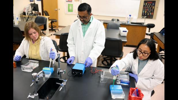 Dr. Sharath Rongali, center, assistant professor of biology at Missouri State University-West Plains (MSU-WP), sets up the agarose gel electrophoresis unit he and his students Macie Tate, left, Mansfield, and Juliana Lopez, Lebanon, will use to test DNA samples as part of an antibiotic-resistant bacteria research project. photo courtesy of MSU-WP