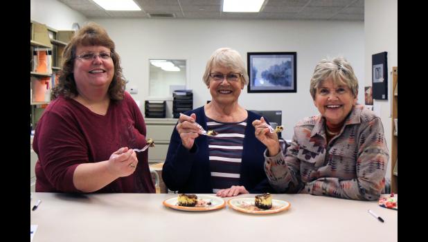 Order a nice cheesecake for the holidays from the Friends of the Garnett Library! Members are selling 13 flavors of Jubilations Cheesecakes as a fundraiser to develop an active learning environment at Missouri State University-West Plains' (MSU-WP) Garnett Library. Orders are due by Oct. 20. Cakes will arrive mid-November. Enjoying a piece of the gourmet Turtle flavor are, from left: Rebekah McKinney, director of library services; Janet McClure, Friends member; and Kay Garrett, events/projects/fundraising chair. photo provided