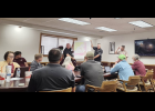 Transportation Director Logan Schwalm (standing, far right) presents the year’s bus route map, held up by middle school principal Chris Cochran (left) and high school principal Dustin Forrest (right). Howell County News/ Amanda Mendez
